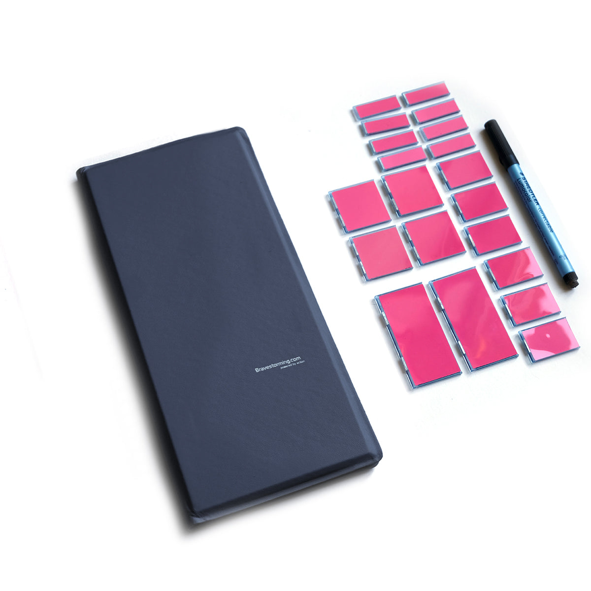 Dark blue notebook with pink sticky notes and a pen on a white background