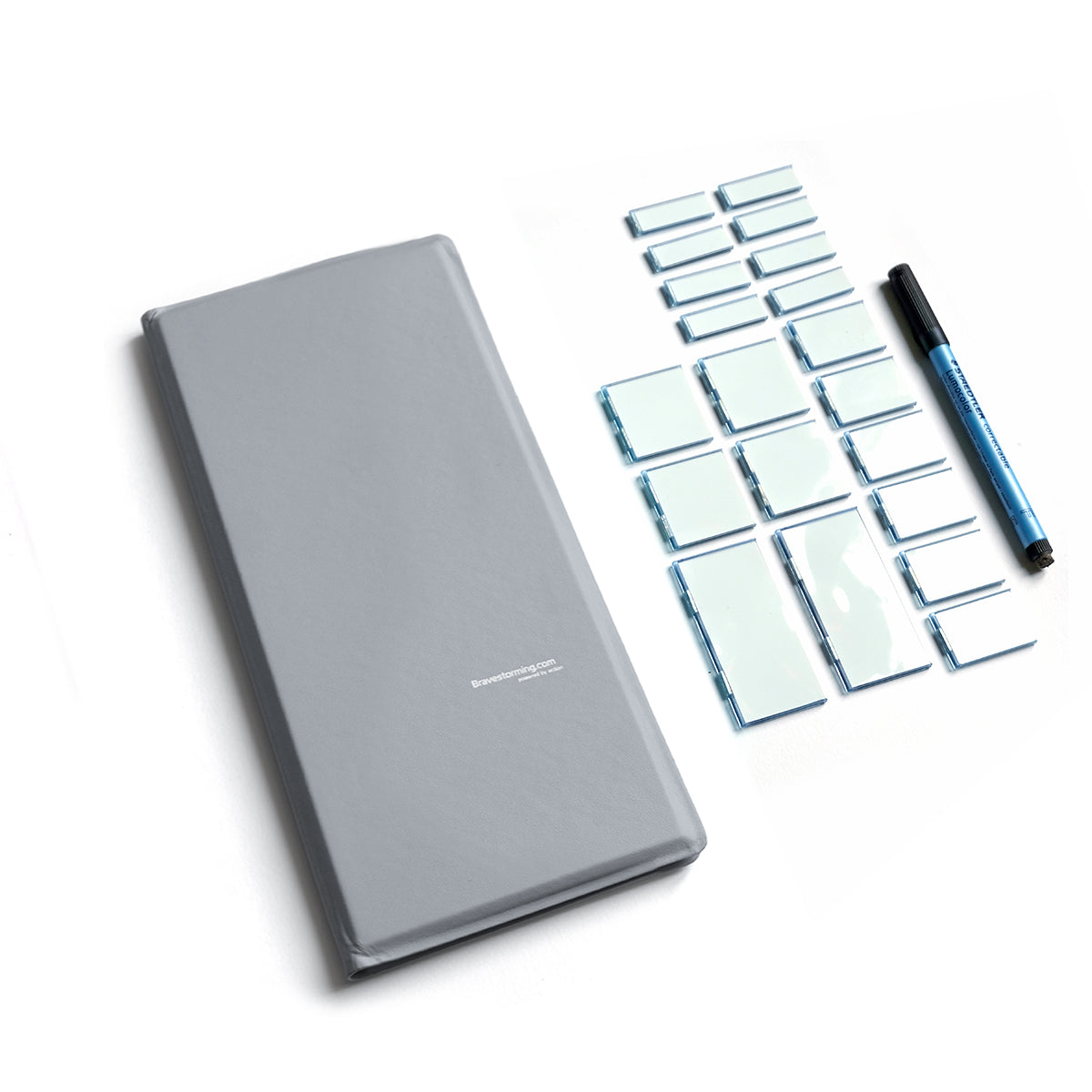 Gray notebook with magnetic tiny whiteboards and a pen on a white background